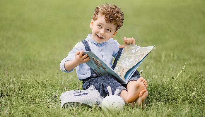 criança lendo livro infantil